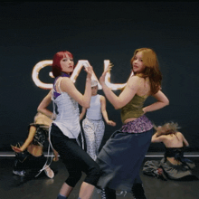 a group of women are dancing in front of a sign that says cml