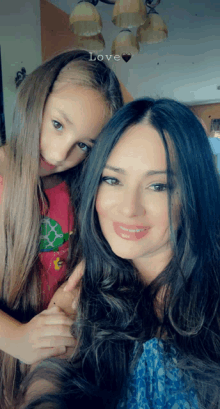 a woman and a little girl are posing for a picture with the word love on the bottom right