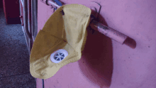 a yellow mask that says n95 is hanging on a pink door