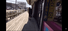 a man walking down a wooden walkway next to a sign that says ' play ' on it