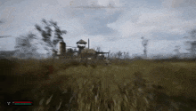 a video game is being played in a field with a house in the distance .