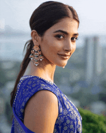 a woman wearing a blue top and gold earrings