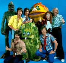 a group of people posing for a picture with a puppet in the middle