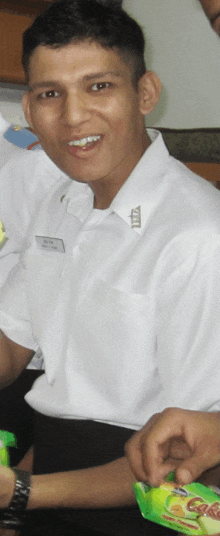 a man in a white shirt has a badge on his chest that says zzz