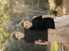 two young boys standing next to each other with one wearing a polo shirt