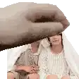 a hand is reaching out towards a woman sitting under a white sheet .