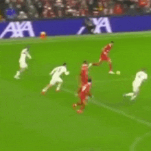 a group of soccer players are playing on a field with a sign in the background that says know you