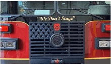 the front of a red fire truck with an american flag on the grille .