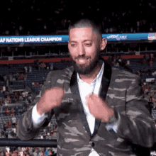 a man in a camouflage suit is standing in front of a sign that says ' af nations league champion '