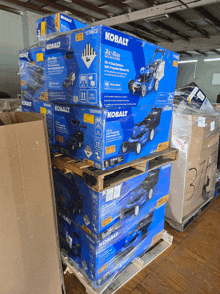 boxes of kobalt lawn mowers are stacked on top of each other on pallets