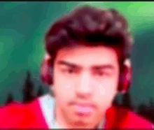 a blurry picture of a man wearing headphones and a red sweater .