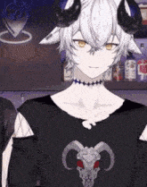 a boy with horns is wearing a black shirt with a skull on it and a choker .