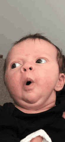 a baby is making a surprised face with his mouth open