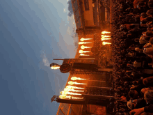 a crowd of people are watching a concert with fire displays