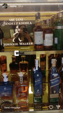 a woman taking a picture of herself with a bottle of johnnie walker