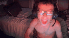 a shirtless boy wearing headphones and glasses screams