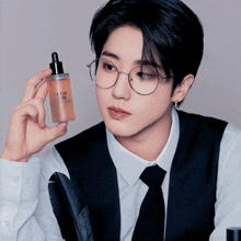 a man wearing glasses is holding a bottle that says fresh air