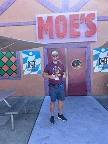 a man giving a thumbs up in front of a moe 's restaurant