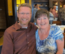 a man and woman are posing for a picture and smiling for the camera