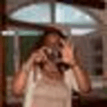 a woman is taking a selfie in front of a mirror .