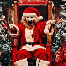 a man dressed as santa claus is sitting on a chair with his arms outstretched