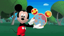 a mickey mouse cartoon character holding a blue ball