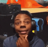 a young man wearing headphones is making a funny face while looking at the camera .