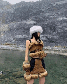 a woman in a furry outfit is standing in front of a body of water