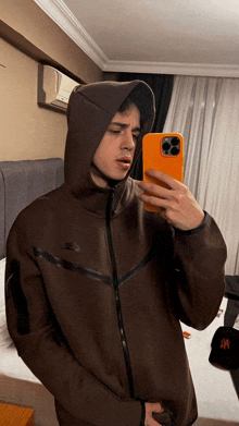 a man wearing a nike jacket takes a selfie with his phone