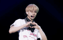 a man wearing a shirt that says " japan " making a heart shape with his hands