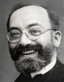 a man with glasses and a beard is smiling for the camera