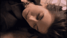 a woman laying down with her eyes closed