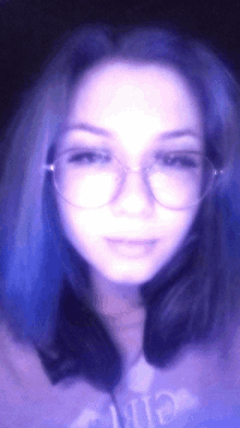 a girl with blue hair is wearing glasses