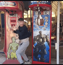 a boy is standing in front of a machine that says boxer