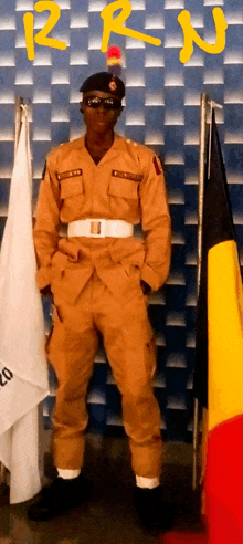 a man in a military uniform stands in front of a wall with the letters rrn on it