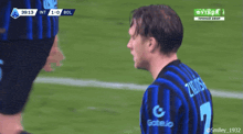 a soccer player wearing a number 7 jersey talks on a cell phone
