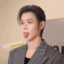 a man in a suit is sticking his tongue out and making a funny face .
