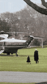 a united states of america helicopter is parked on a grassy field