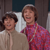 two young men are standing next to each other and one of them is wearing a floral shirt