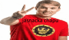 a man wearing a red shirt with the word jasnacka chapu on it is giving a peace sign .