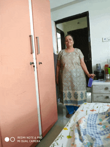 a woman standing in a room with a redmi note 6 pro in the background