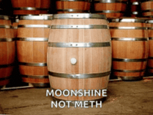 a stack of wooden barrels with the words moonshine not meth on the bottom