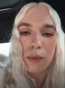 a woman with blonde hair is looking at the camera