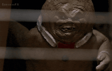 a gingerbread man with a red bow tie is behind a fence