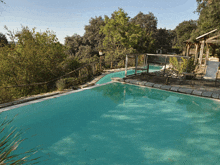 a large swimming pool is surrounded by trees and a gazebo