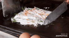 a person is cooking food on a griddle and the words made in animotica can be seen in the corner