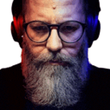 a man with a beard and glasses is wearing headphones and looking at the camera .