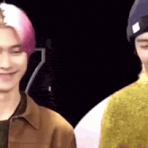 a close up of two men standing next to each other and smiling .