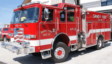 a red sandy fire truck is parked in front of the sandy fire district