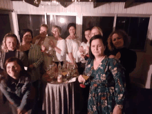 a group of women standing around a table with wine bottles